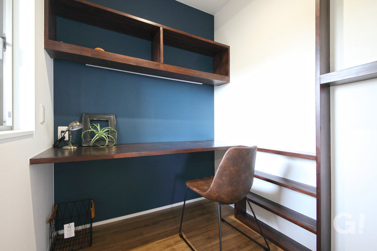 ブルーの壁紙がアクセントの統一感のある書斎