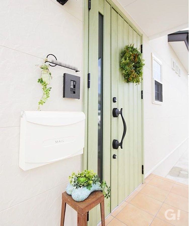 白い外壁によく似合う、優しいグリーンの玄関ドア