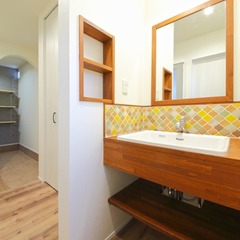 カラフルなタイルと木の色がマッチした洗面所