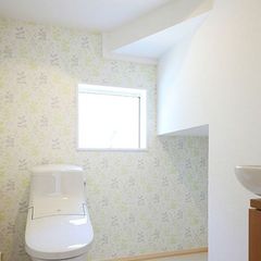小窓と淡い色のクロスで清潔感のあるトイレ