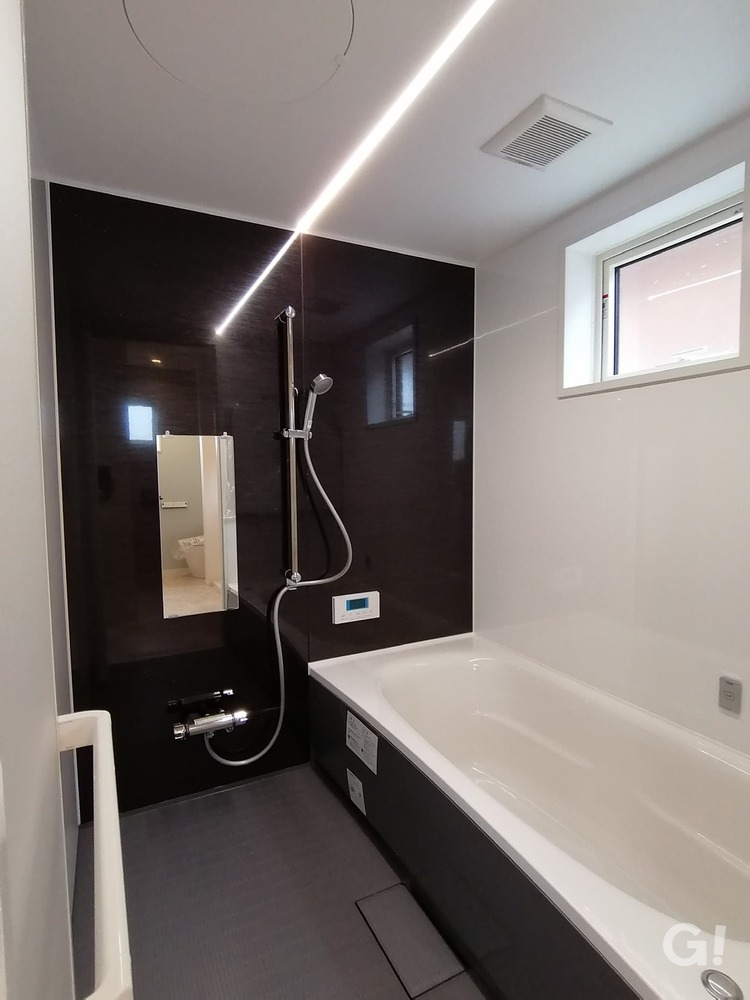 『広々とした浴槽で快適な入浴が叶うシンプルモダンな浴室』の写真