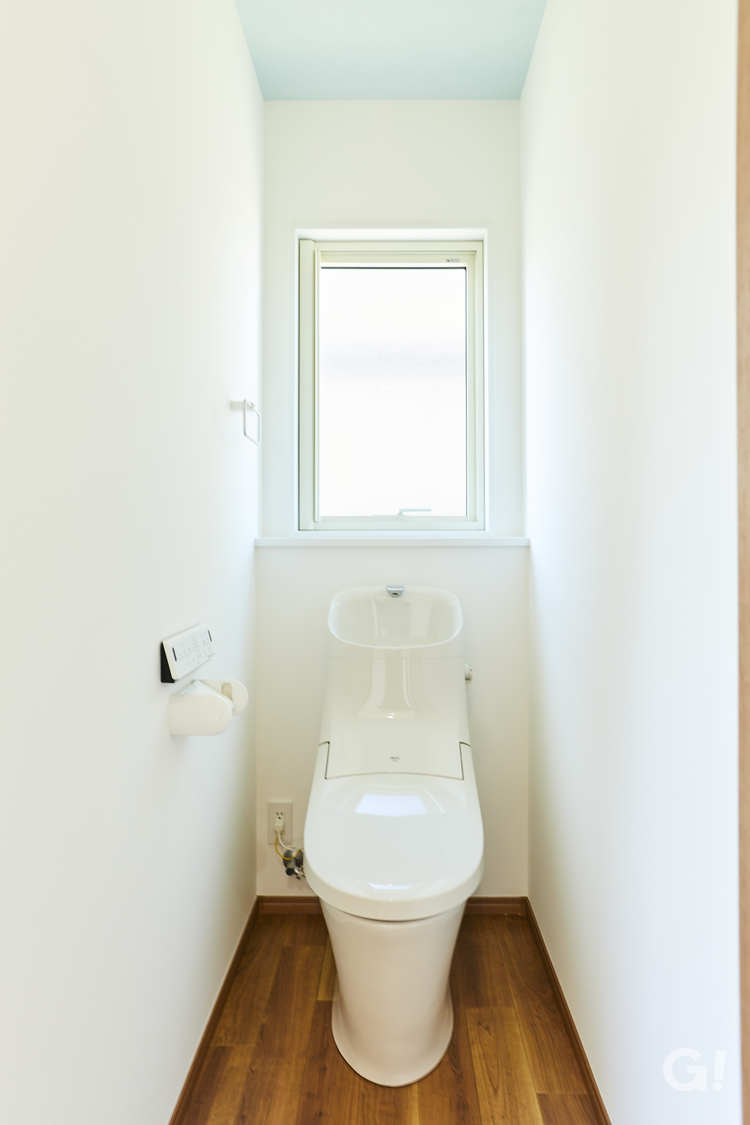 ライトブルーの天井が清々しい印象を届けてくれるシンプルなトイレ
