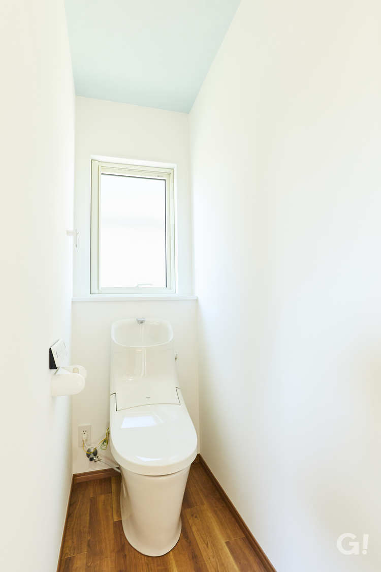 ライトブルーの天井から清潔感と清々しさが届くシンプルなトイレ