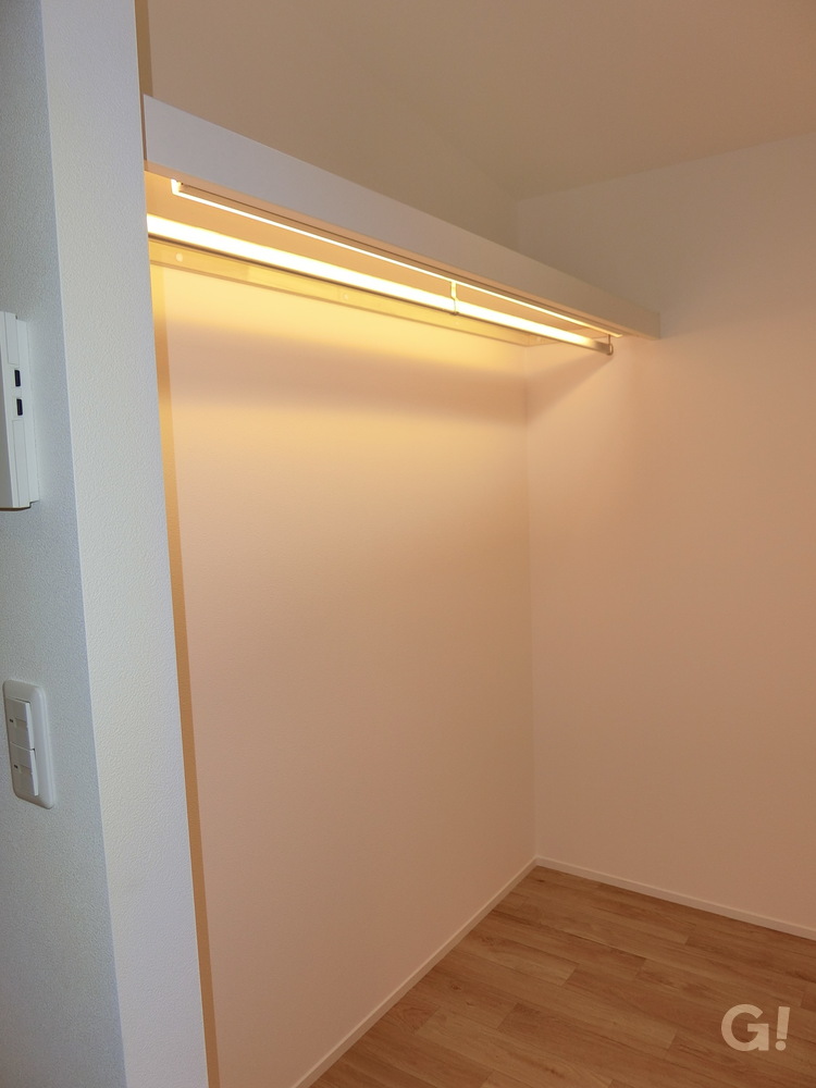 『間接照明でやわらかく照らされるオープンタイプの収納があるシンプルモダンな洋室』の写真