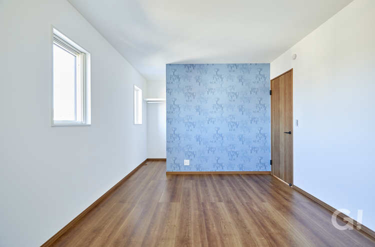 『ブルーのアクセントウォールが爽やか！収納空間もあって使い勝手のいい北欧スタイルの洋室』の写真