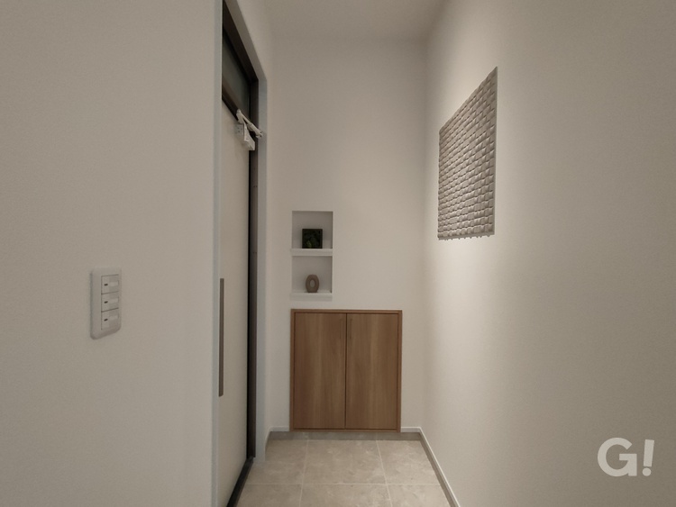 『凹凸感のあるエコカラット壁面がお洒落！優しい空気でお出迎えしてくれるシンプルモダンな玄関』の写真