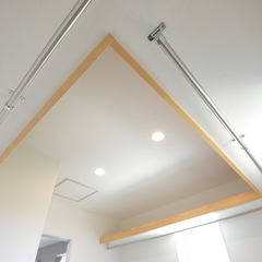 天井に設けられたシンプルな物干しがある洋室
