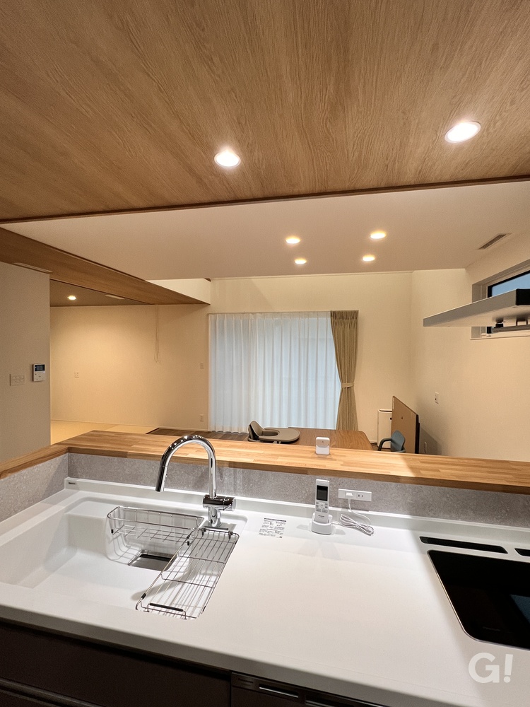 『家族の様子を見守りながら家事をこなせるシンプルモダンなオープンキッチン』の写真