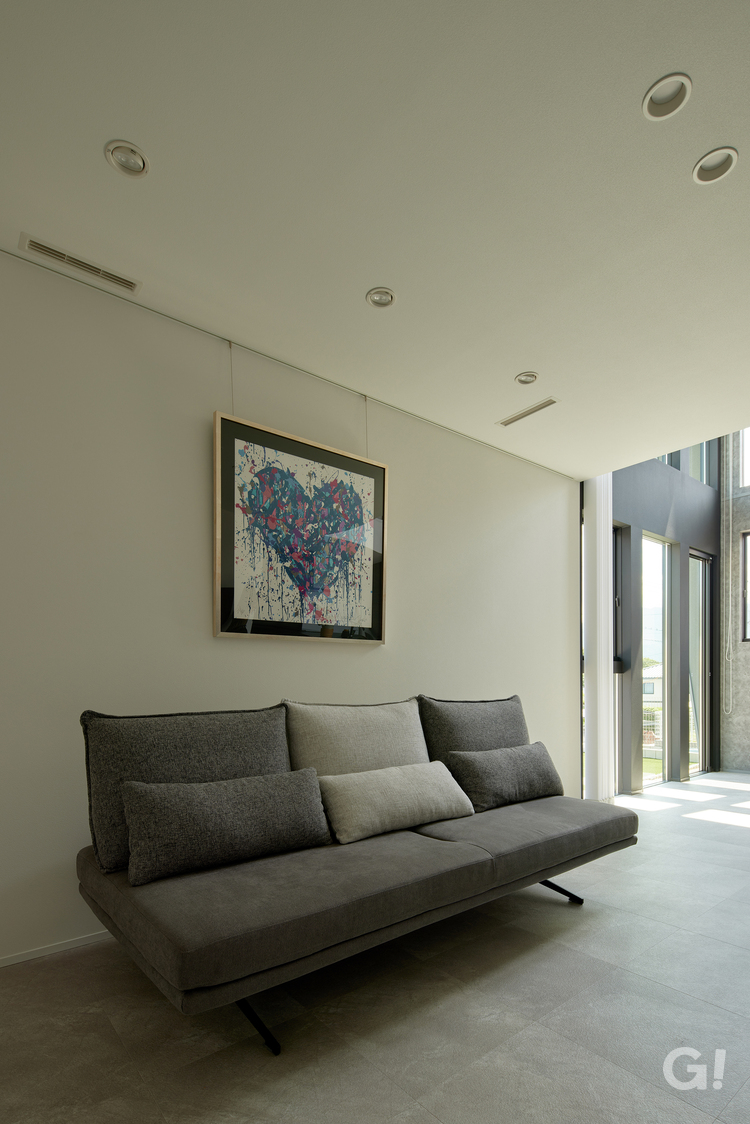 『お気に入りのソファで時間を忘れて寛ぐシンプルモダンなリビング』の写真