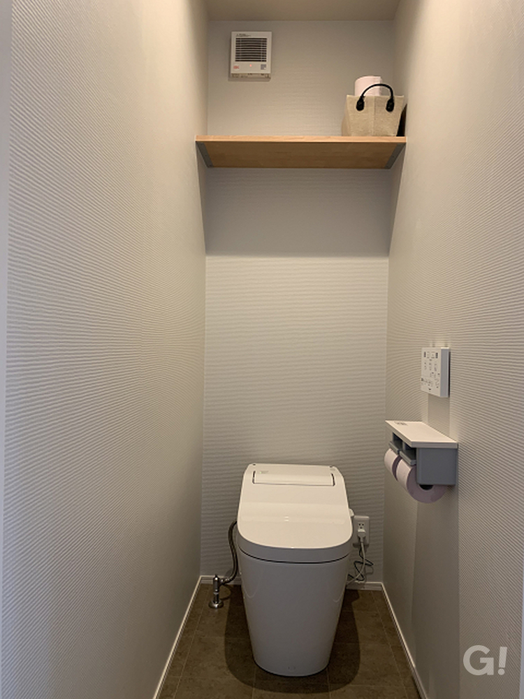 パステルグレーのデザインクロスが落ち着くシンプルなトイレ