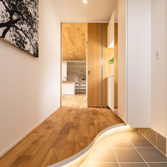 湾曲の上がり框が高級感漂う注文住宅のスタイリッシュな玄関ホール