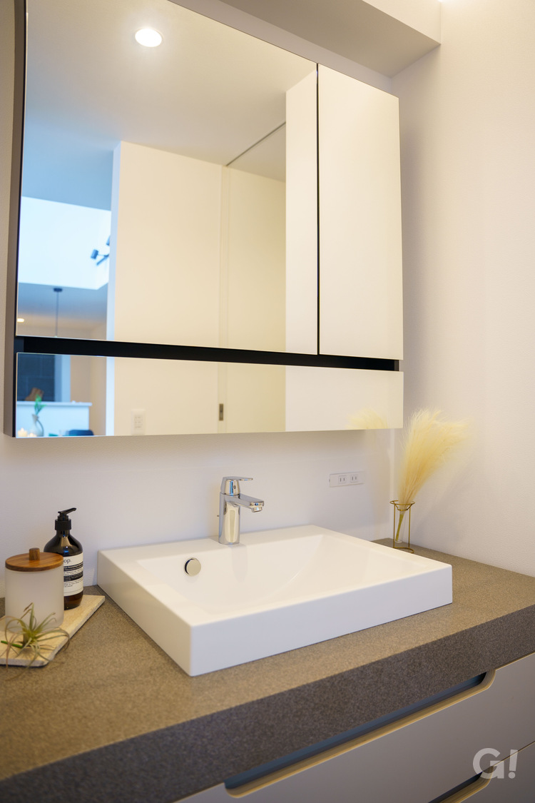 『白で艶のあるスクエアタイプの洗面ボウルが美しいシンプルモダンな洗面所』の写真