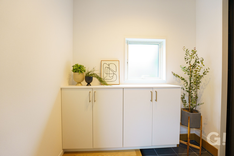 『漆喰で調湿＆消臭効果を発揮！白で統一され美しく清々しいシンプルな玄関』の写真