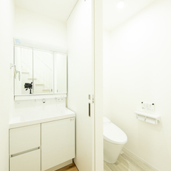 白で明るく清潔感漂う空間！引き戸で仕切られたトイレへも続くシンプルな洗面室