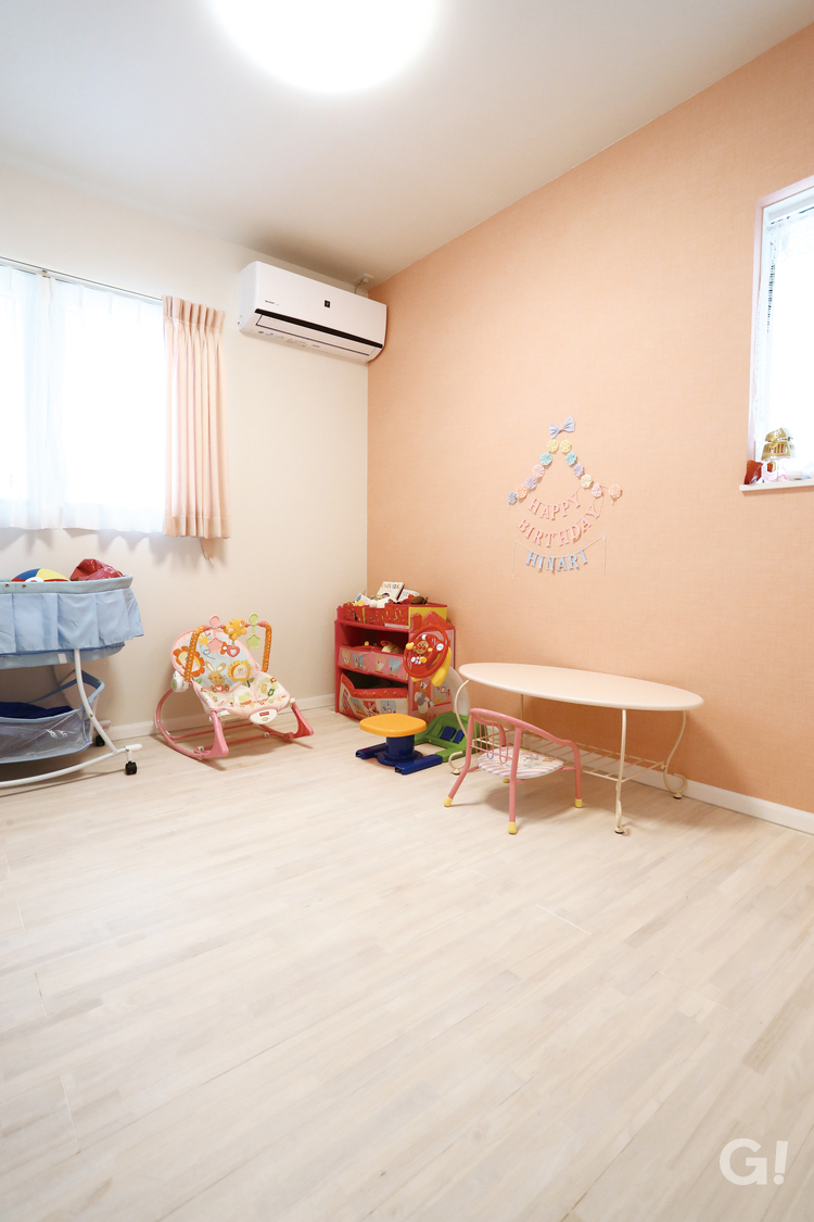やさしいピンクのデザインクロスが可愛い子供部屋