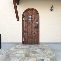 木製のアーチ型扉がかわいらしい南欧風の玄関