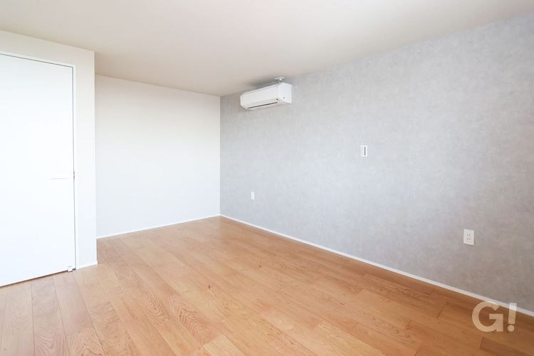 グレーのアクセントクロスと木目の床を組み合わせた、シンプルモダンな主寝室・寝室インテリアの施工事例。