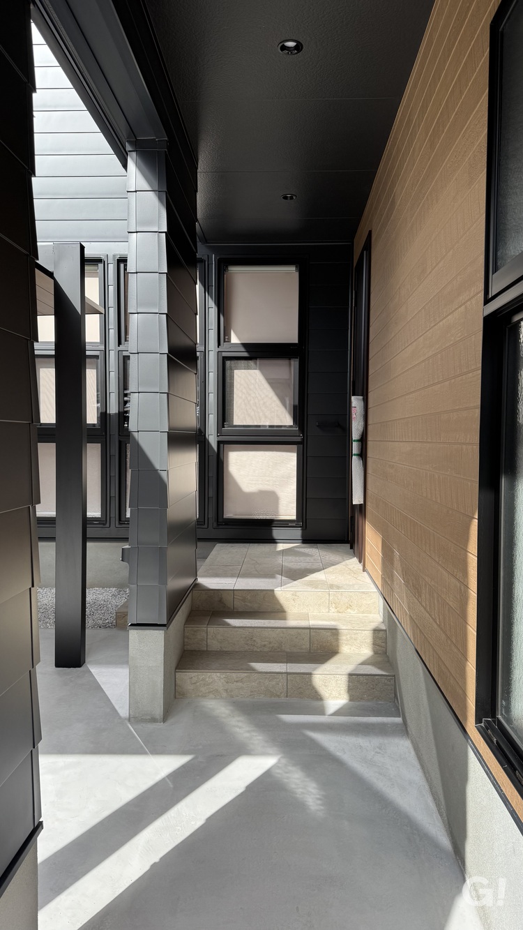 『静かで落ち着きある印象でお出迎えしてくれるシンプルモダンな玄関アプローチ』の写真