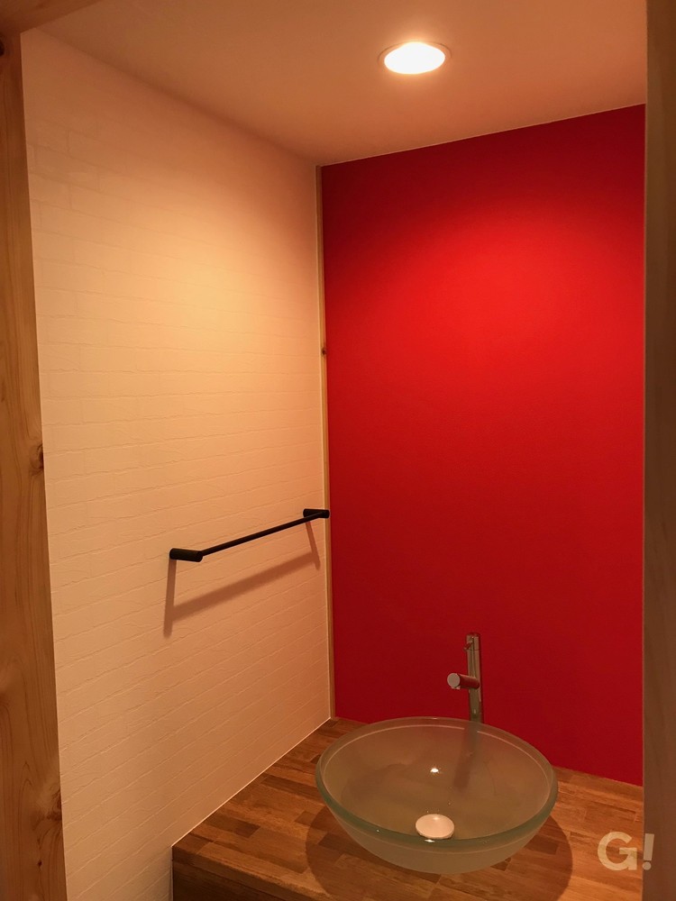 『インパクトを与えてくれる赤が素敵！遊び心のあるアメリカンな家の洗面所』の写真