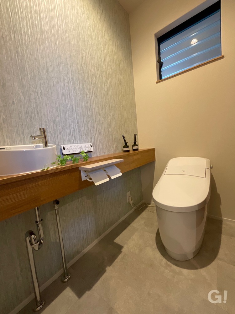 『アウトドアグッズも良く似合う！白で艶のある造作手洗いが美しいシンプルモダンなトイレ』の写真