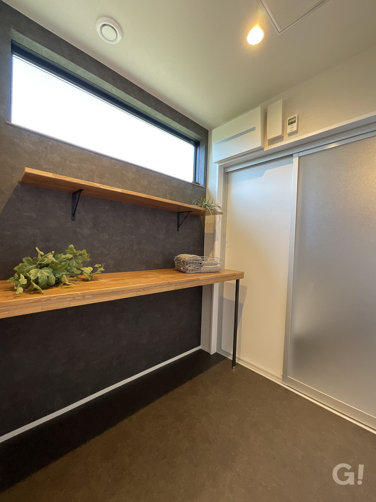 『浴室へとフラットに繋がりアウトドア気分で過ごせる空間がいいシンプルモダンな脱衣室』の写真