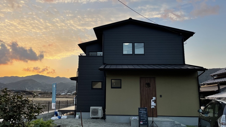 『夕焼け空に美しく映える！おうちアウトドアをタップリ楽しめるシンプルモダンな家』の写真