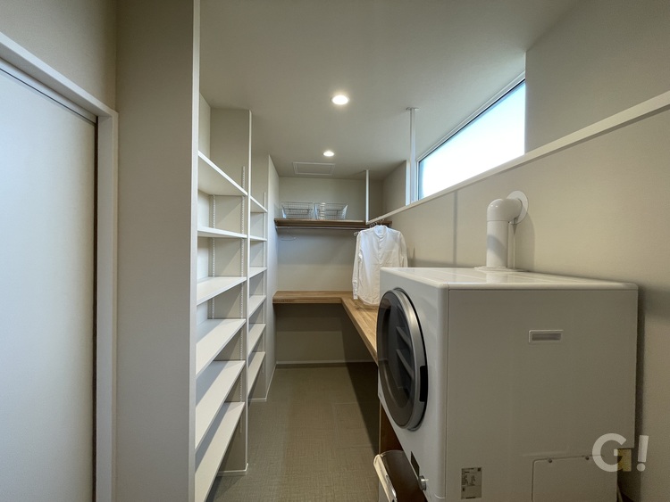 『お洗濯作業をひとつの空間でこなせるのが嬉しいシンプルモダンなランドリールーム』の写真