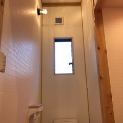 アウトドアで使うライトのような照明が光を放つシンプルなトイレ