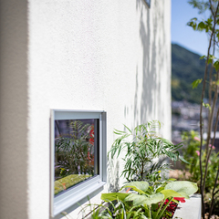 外の花壇をみせる地窓のあるお家