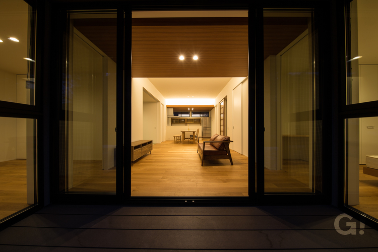 室内からやわらかい灯りが漏れて幸せ伝わる美しい規格住宅のウッドデッキ