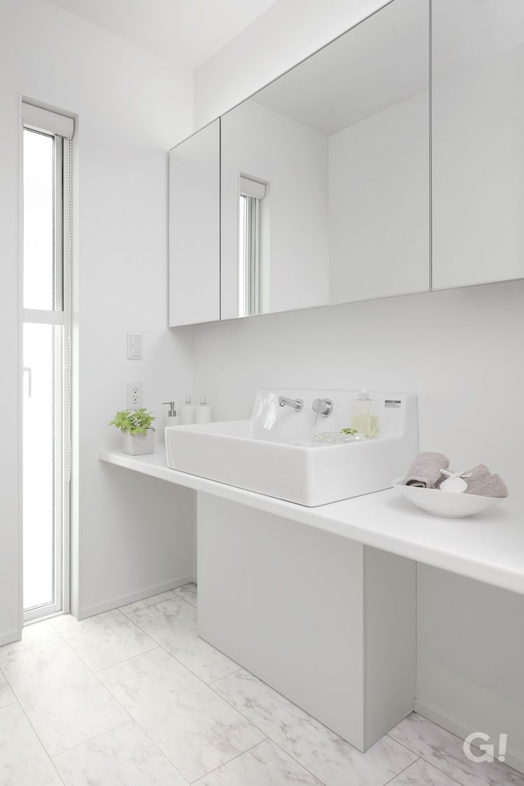 白で統一した美しい規格住宅の洗練されたデザインの洗面所の写真