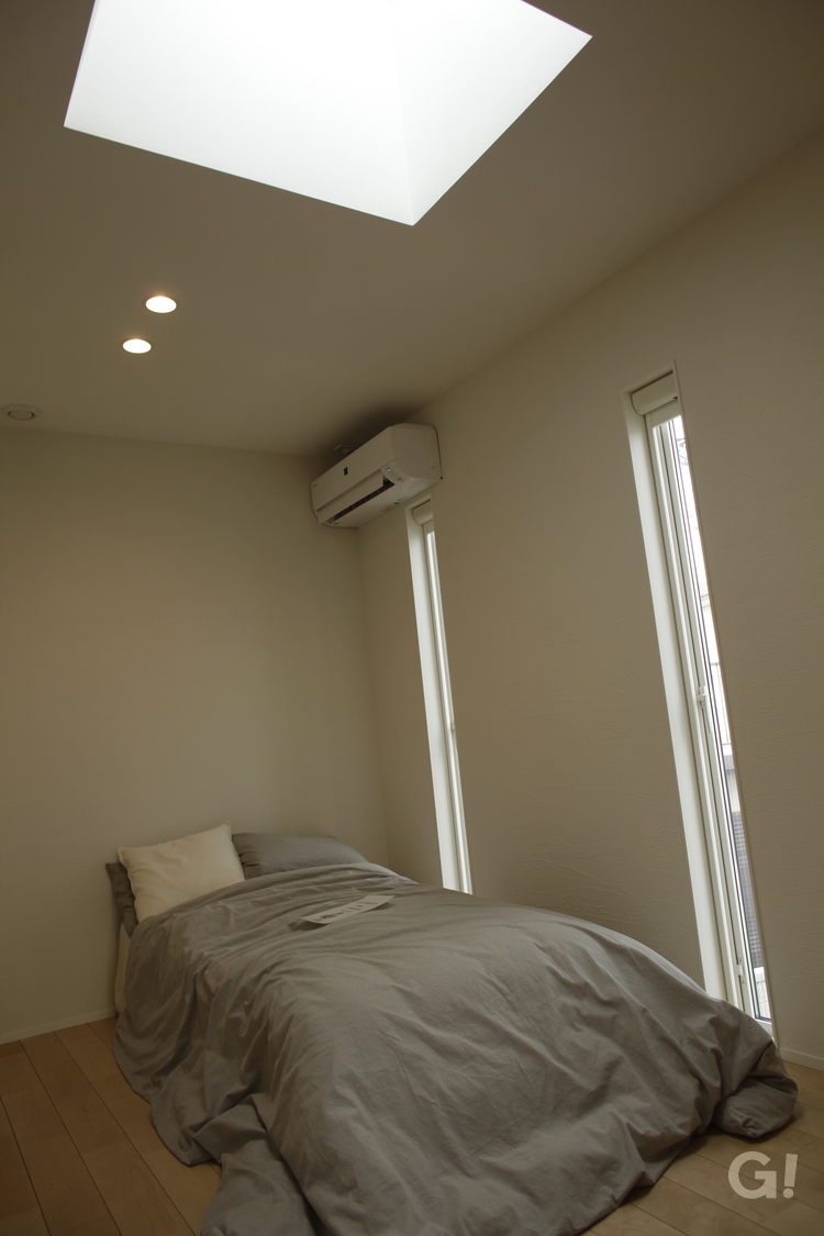 美しい規格住宅の陽光が差し込む落ち着く寝室の写真
