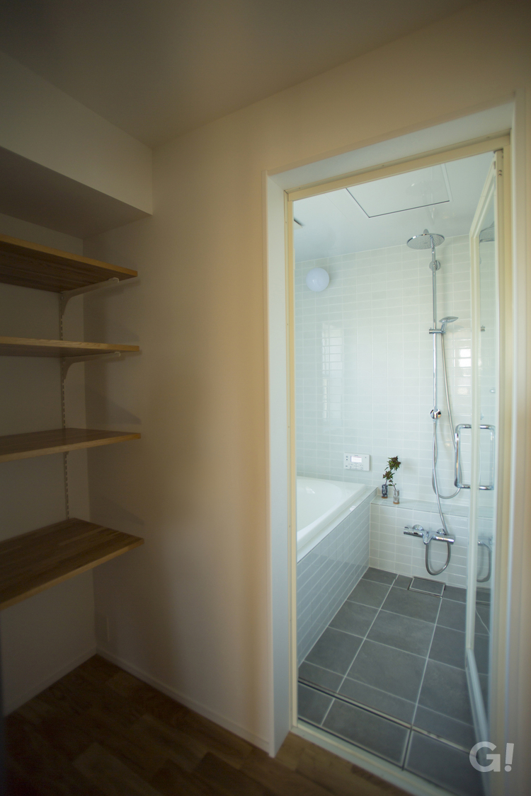 水回りに最適なタイルに囲まれた美しい規格住宅の浴室空間の写真