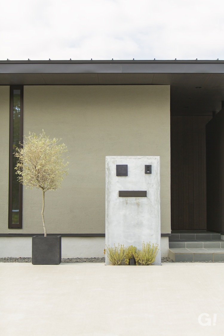 オシャレなグリーンがやさしい雰囲気になる美しい規格住宅の玄関アプローチの写真