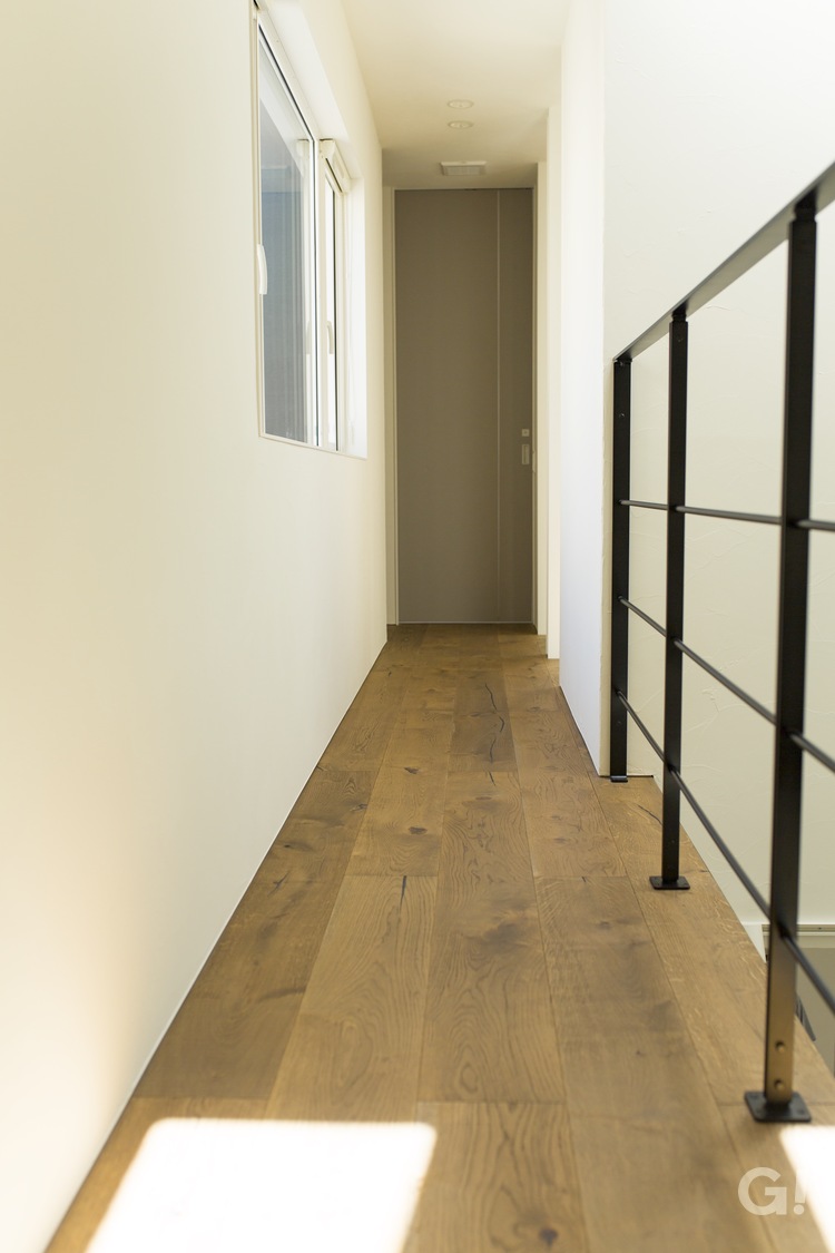 美しい規格住宅のアイアン手摺がかっこいいアクセントになる吹き抜け廊下の写真