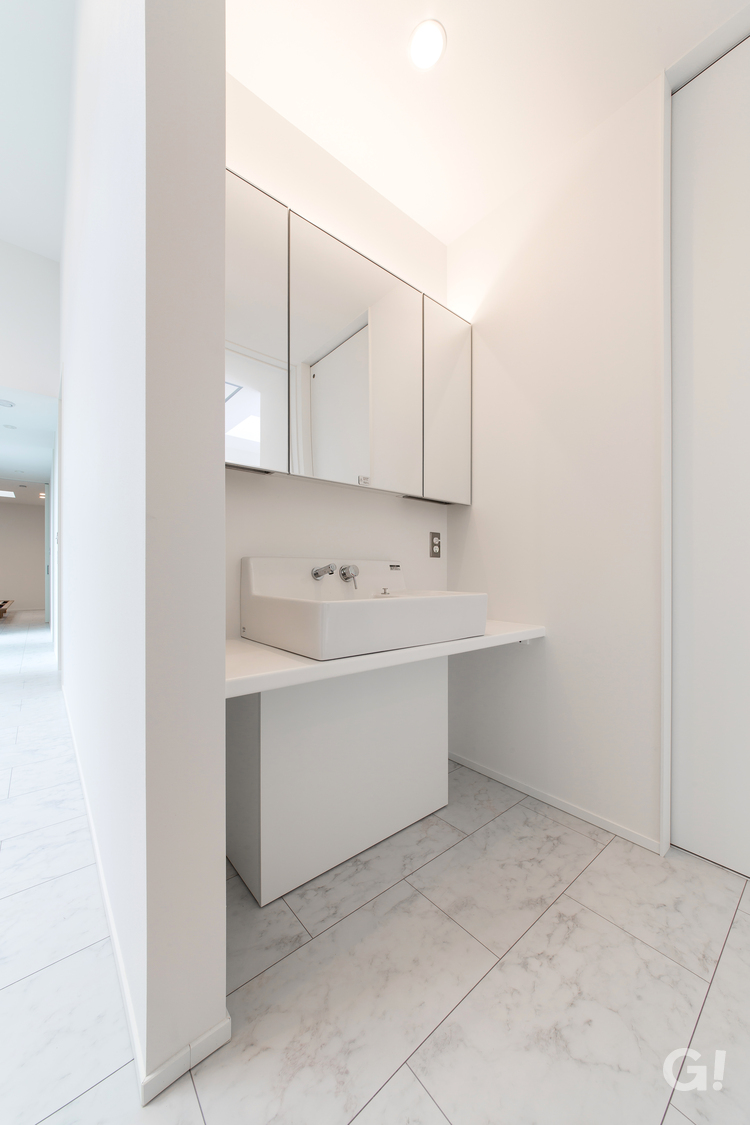 ホワイトベースが美しい規格住宅のホテルライクな造作洗面カウンターの写真