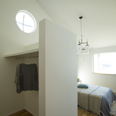 丸窓がオシャレな心地よさを演出する美しい規格住宅の寝室