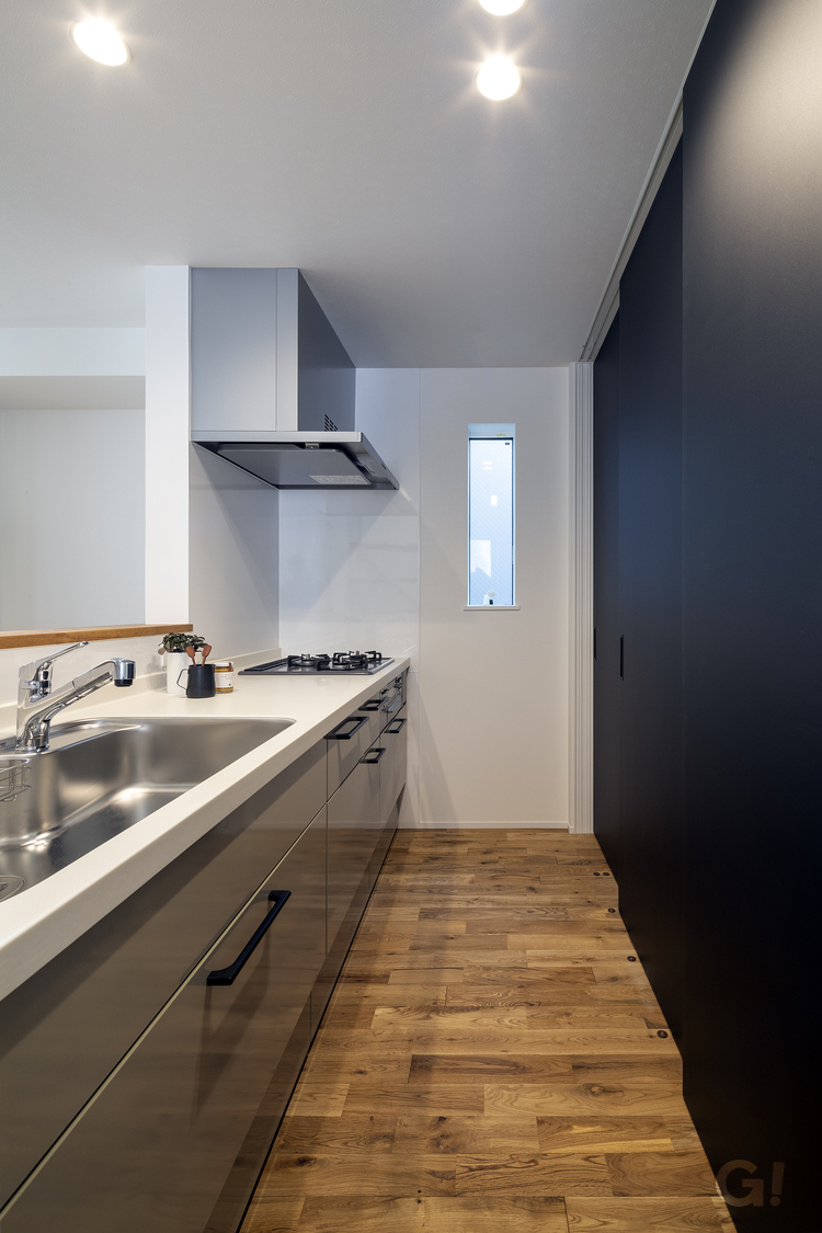 『黒い収納扉が繊細で上品さを演出！自然素材を取り入れたシンプルモダンなキッチン』の写真