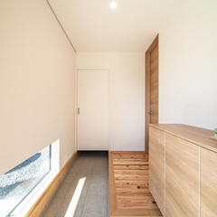 地窓から届く陽の光が心地よく癒してくれる注文住宅の玄関