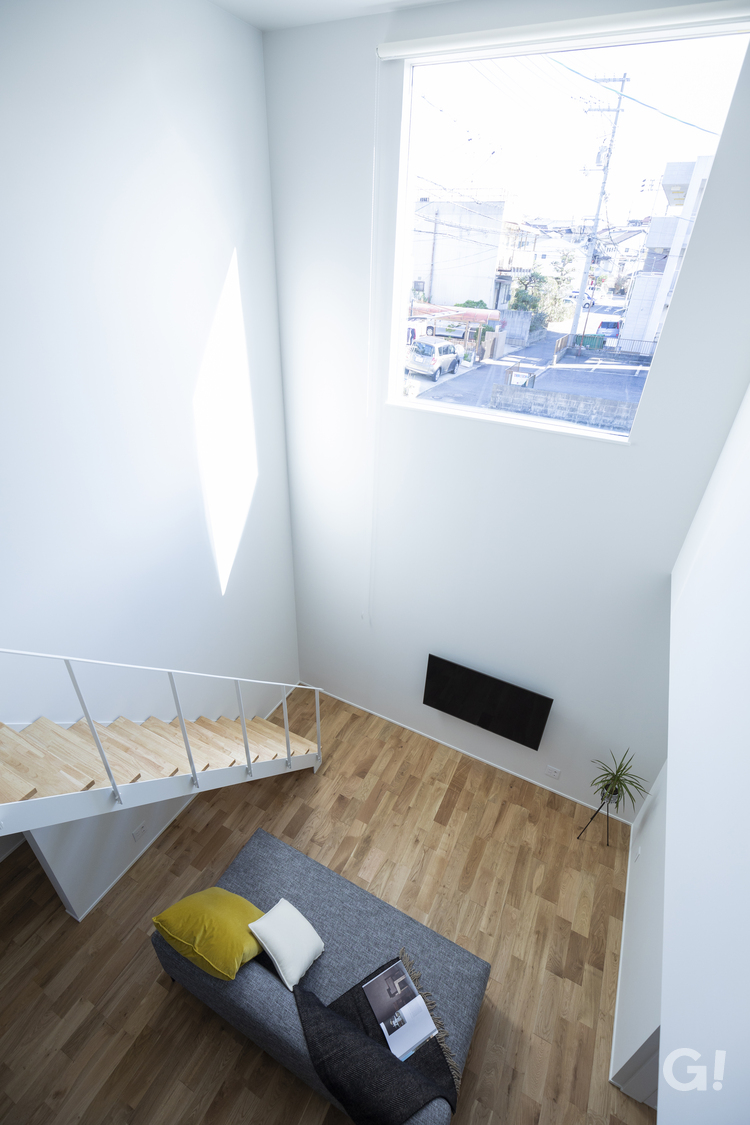 大きな吹き抜け窓から陽の光がキラキラ降り注ぐデザイナーズ住宅のリビング