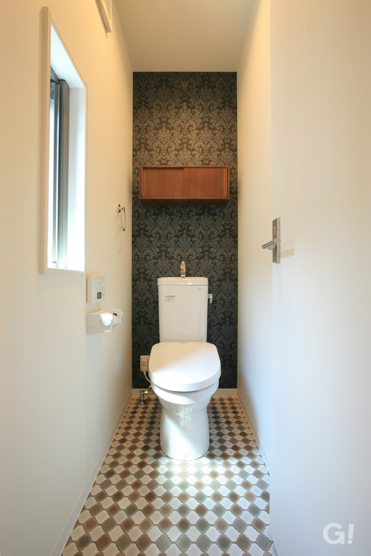 高級感漂う壁紙と床のデザインが特徴的なトイレのあるデザイン住宅の写真