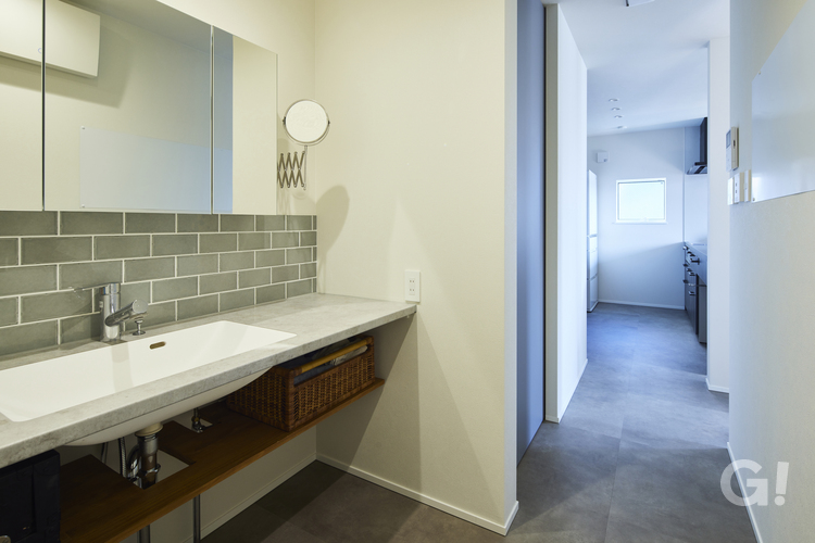 廊下でつながるデザイナーズ住宅の家事効率にも優れたスタイリッシュな水回り空間の写真