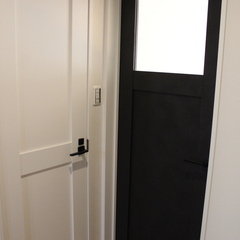 2色で繊細で上品な空間演出を叶えたシンプルモダンな廊下に繋がるドア