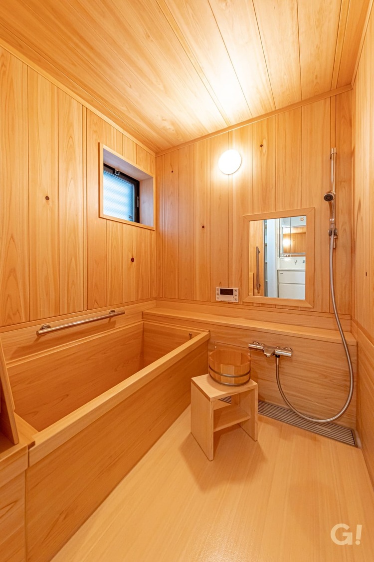 『木のやわらかい香りに包み込まれ至福のひと時を過ごせる和風な浴室』の写真