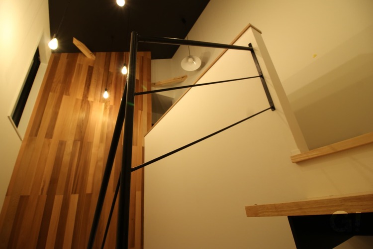 『縦のラインが強調されるレッドシダーの壁がかっこいいシンプルモダンなストリップ階段』の写真