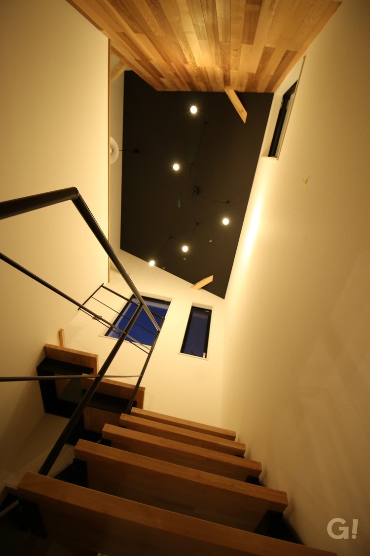 黒い天井で照明が光り輝き夜空のような美しさを魅せてくれるシンプルモダンな階段