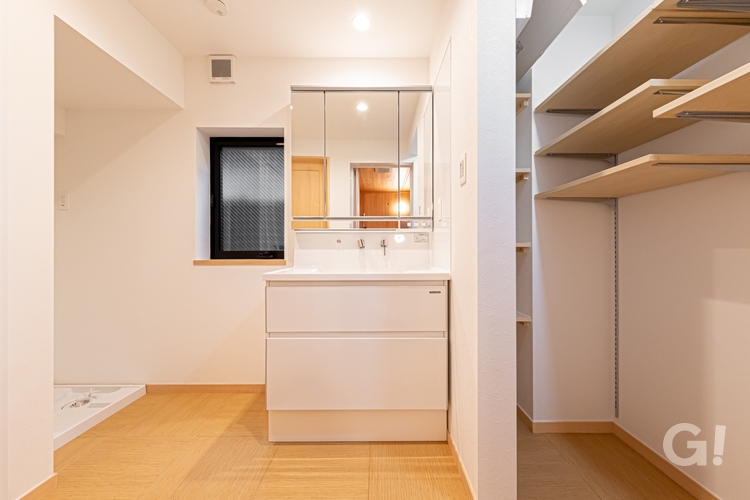 『漆喰の壁で快適な空間！収納スペースへフラットに繋がり整理整頓もできるシンプルモダンな洗面所』の写真