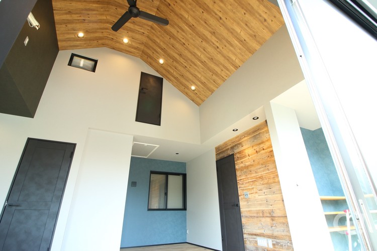 『個性的なデザインの天井でシーリングファンがカッコよく廻るシンプルモダンなLDK』の写真