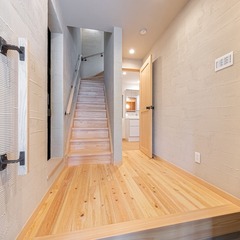 無垢材の床がLDKまで優しく誘導してくれるシンプルモダンな玄関ホール