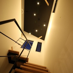 黒い天井で照明が光り輝き夜空のような美しさを魅せてくれるシンプルモダンな階段